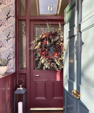 burgundy front door with large festive wreath