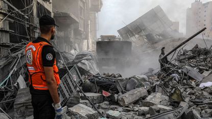 Gaza rescue worker looks a post-airstrike rubble