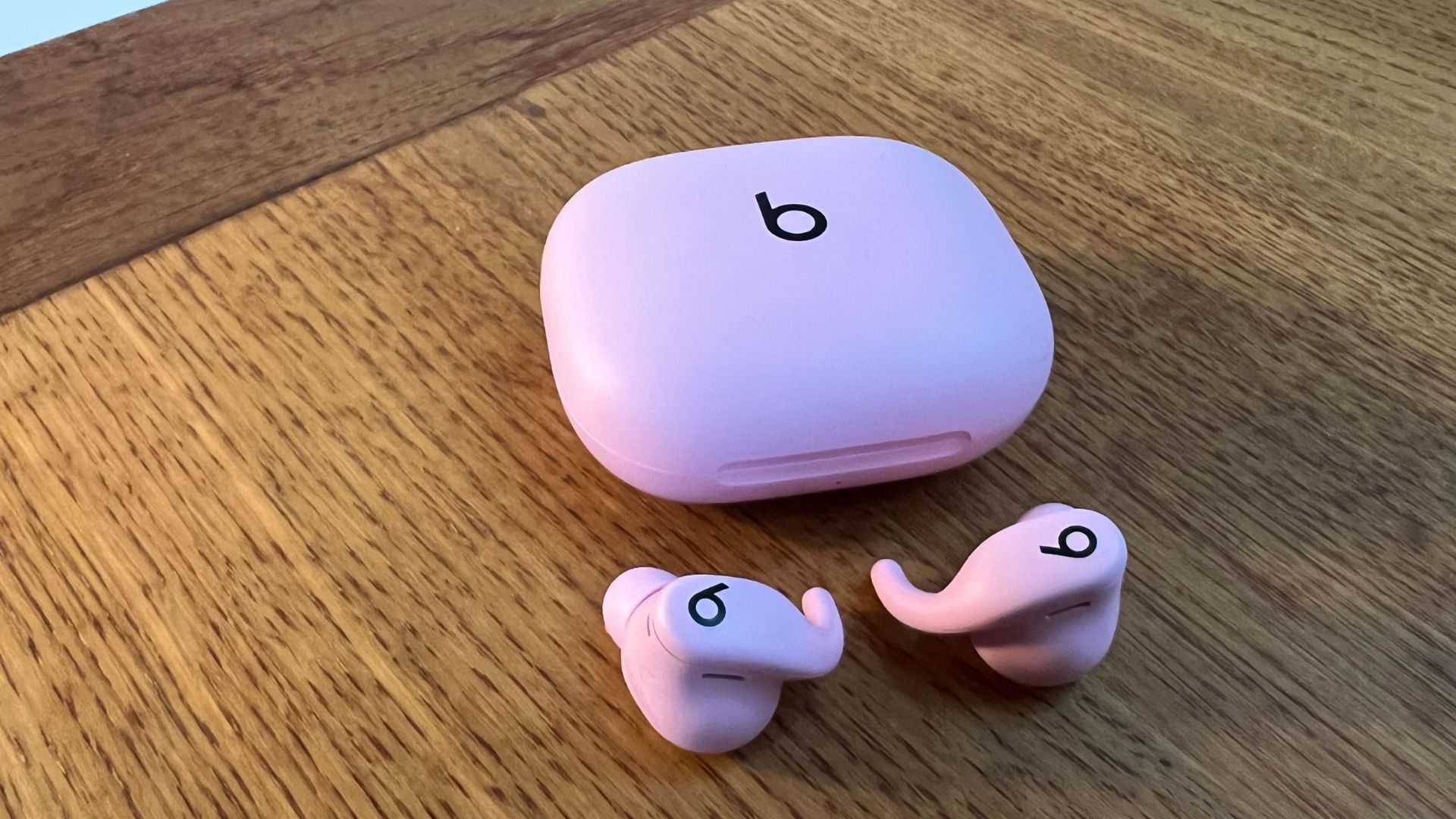 Grace Walsh&#039;s Powerbeats Fit sitting on wooden table