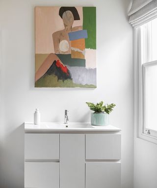 White bathroom with colorful artwork