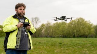 Reviewer Adam Juniper flying the Mavic 3T Enterprise thermal drone wearing a high-vis top