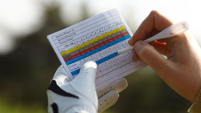 Golfer writes score on a scorecard - close up