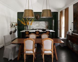 kitchen-dining room with dark green feature wall, dark wooden furniture and rustic decor