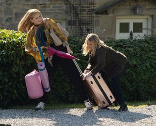Bernice Blackstock pulling along a pink suitcase as Nicola King stops her from escaping.