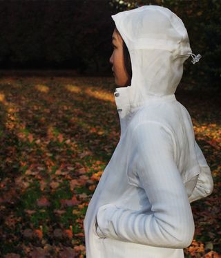 Woman wearing white jacket with the hood up