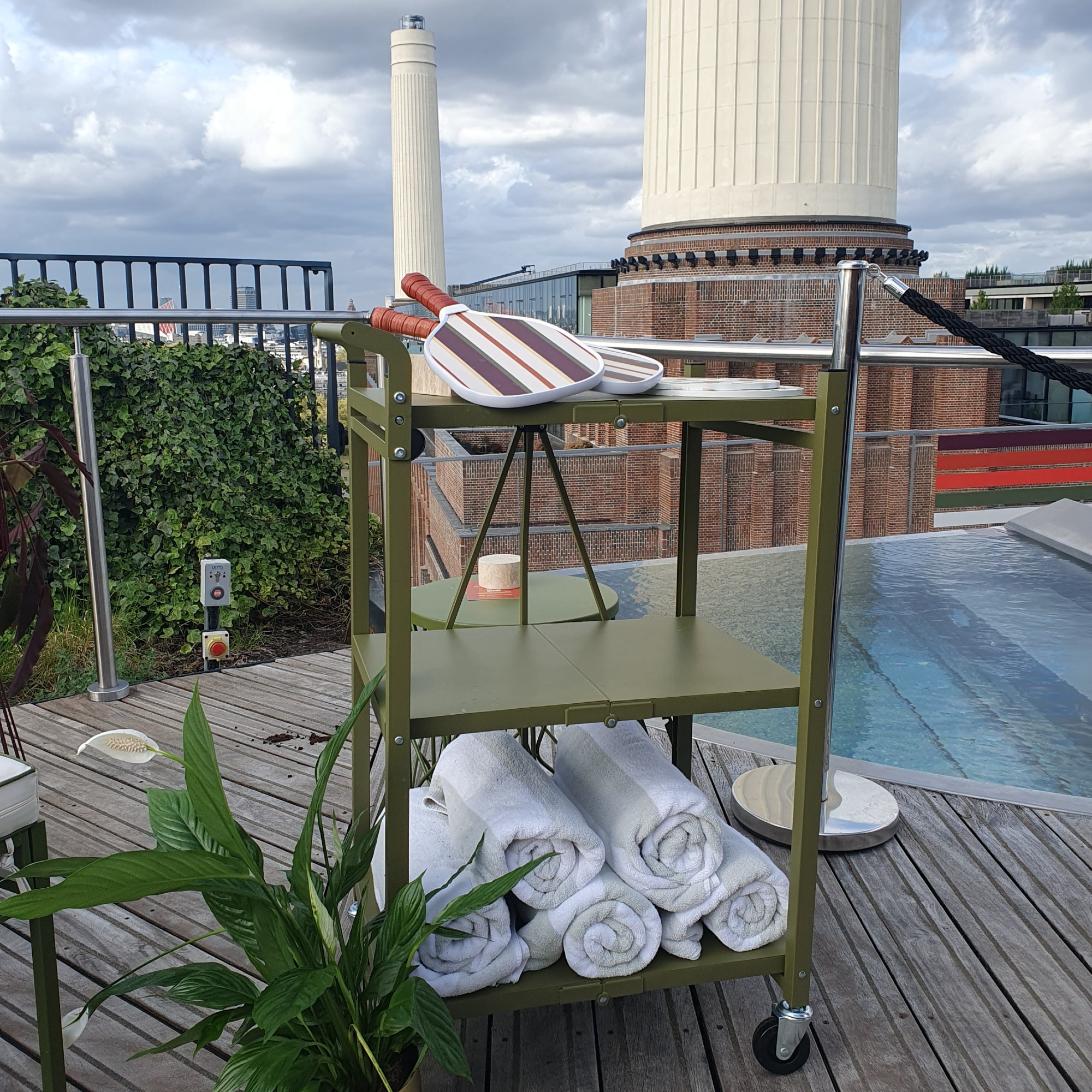 The foldable trolley in green from QVC's Studio 70 outdoor collection next to a pool at the press view of the range