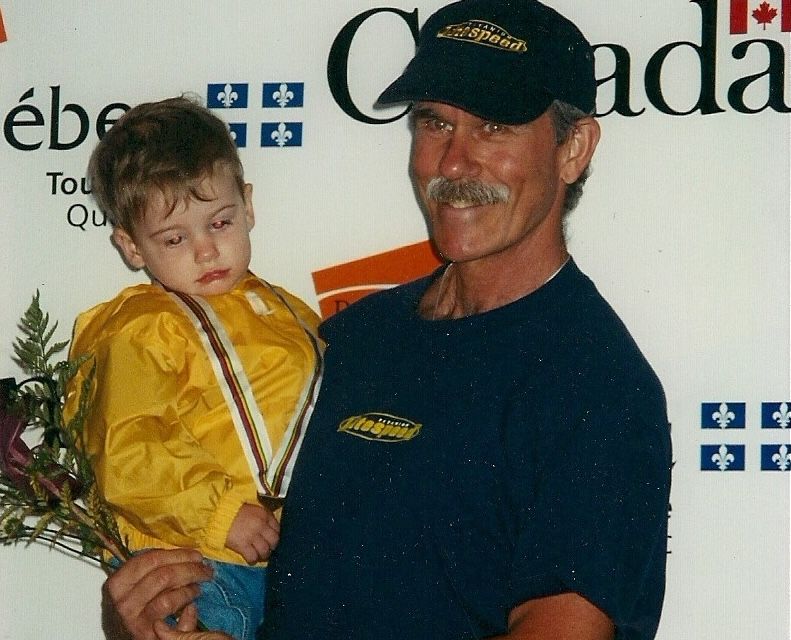 Bill Humphreys holds his son Ian after winning a bronze medal at Masters Worlds for mountain biking in Quebec in 1999