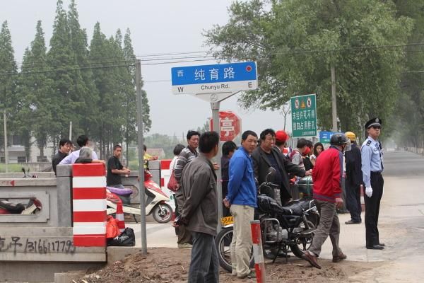 Workers from a factory in the industrial zone wait for the race to pass.