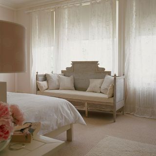 bedroom with gustavian sofa and white long curtains