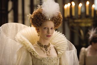 cate blanchett as elizabeth i of england with her hair up and wearing a large white gown