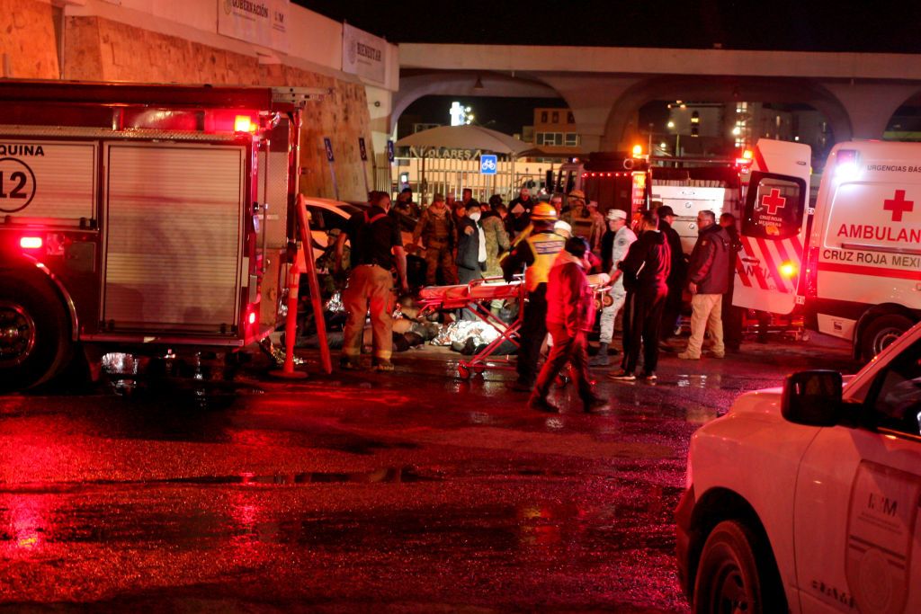  Rescuers work to take the injured and the corpses of the victims out of the premises after a fire at an immigration detention center in Northern Mexico