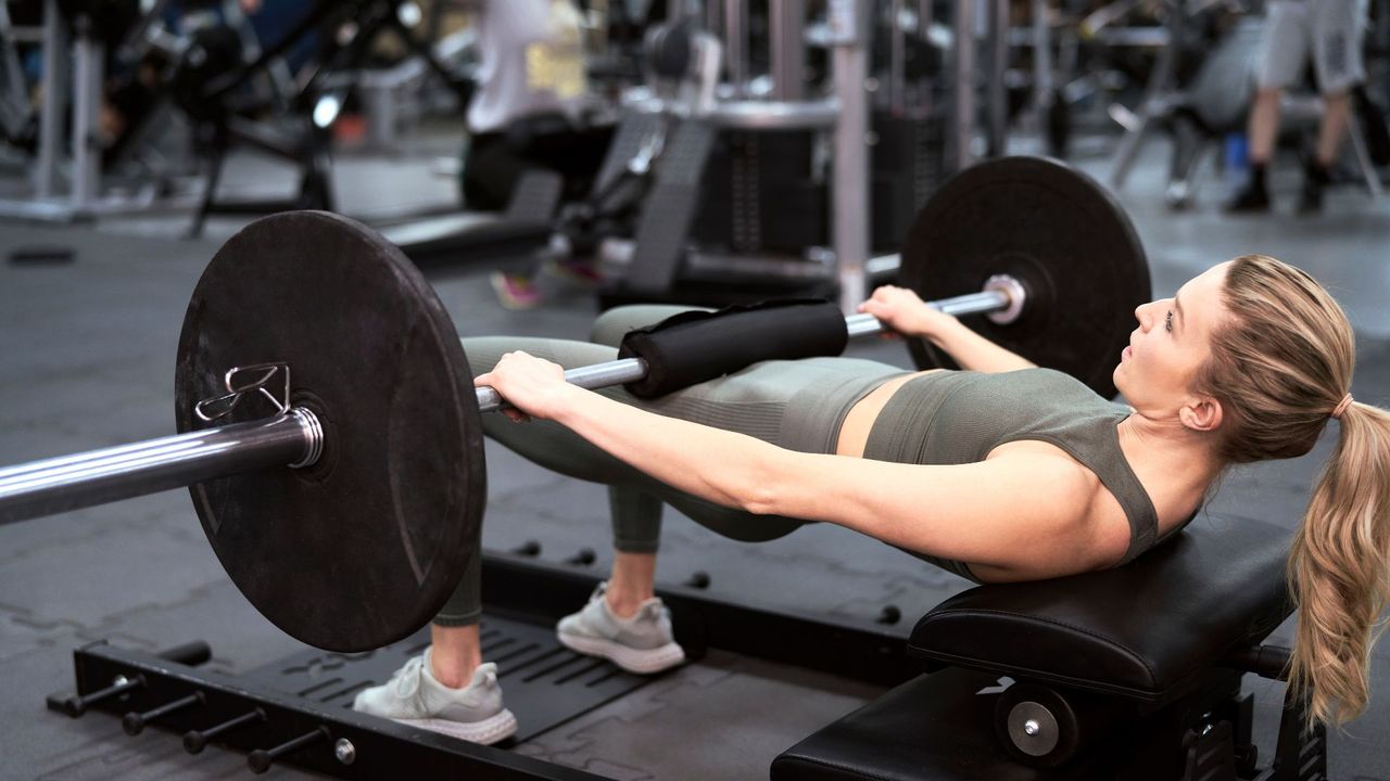 A woman performing barbell hip thrusts