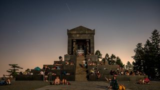 星星落在寺廟上方的天空中,那裡有星星的人群。