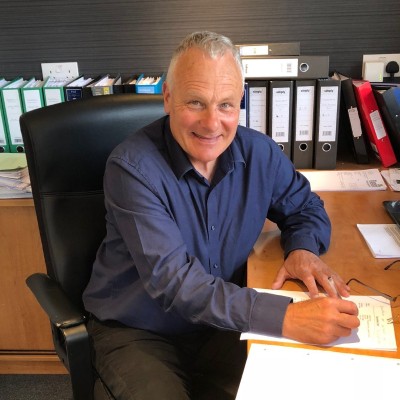 A picture of a man in a blue shirt at a desk