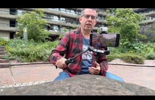 Hohem iSteady V3 gimbal being used to film a person on an iPhone