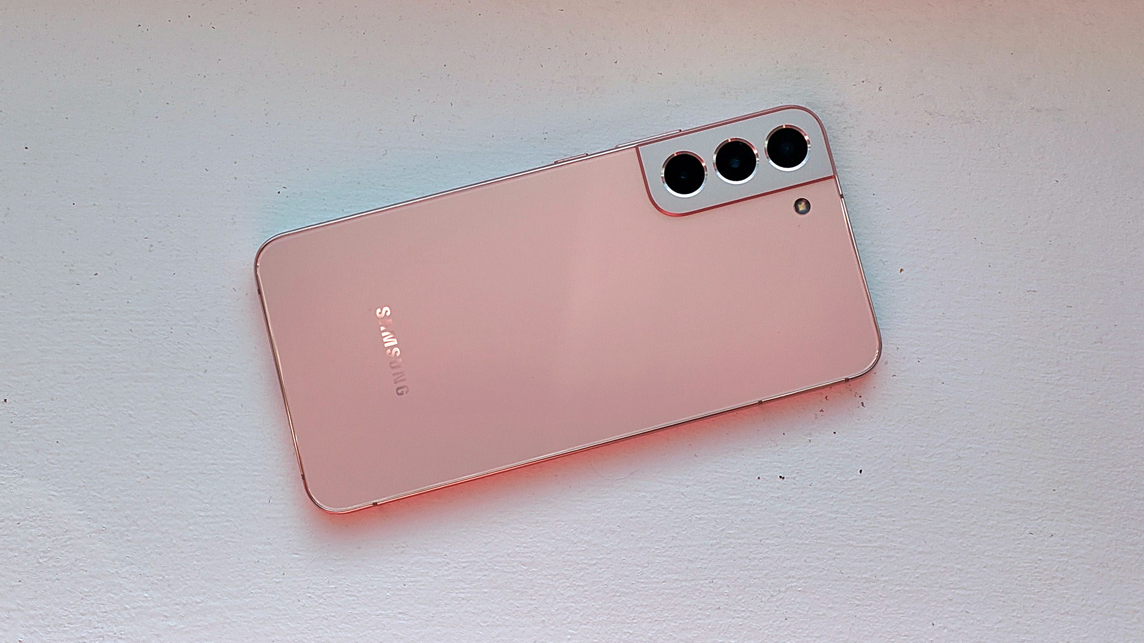 A pink Samsung Galaxy S22 Plus from the back on a white surface