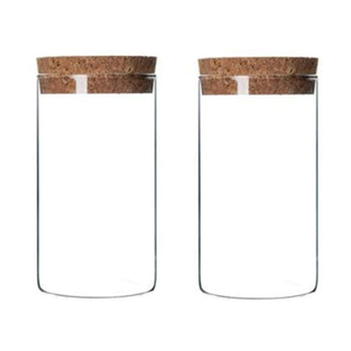 A pair of glass storage jars with cork lids