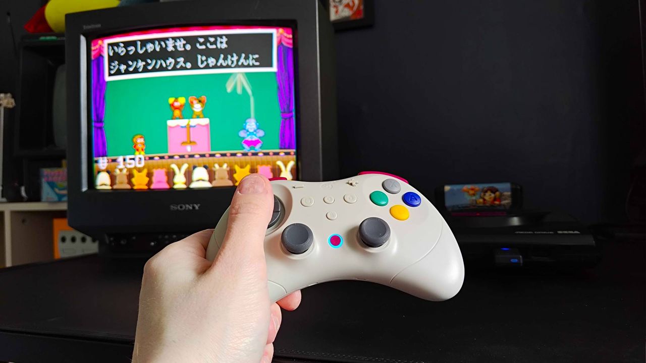 Hands using Gulikit Elves 2 Pro to play Alex Kidd in Miracle World on a Sega Mega Drive connected to a Sony Trinitron CRT TV.