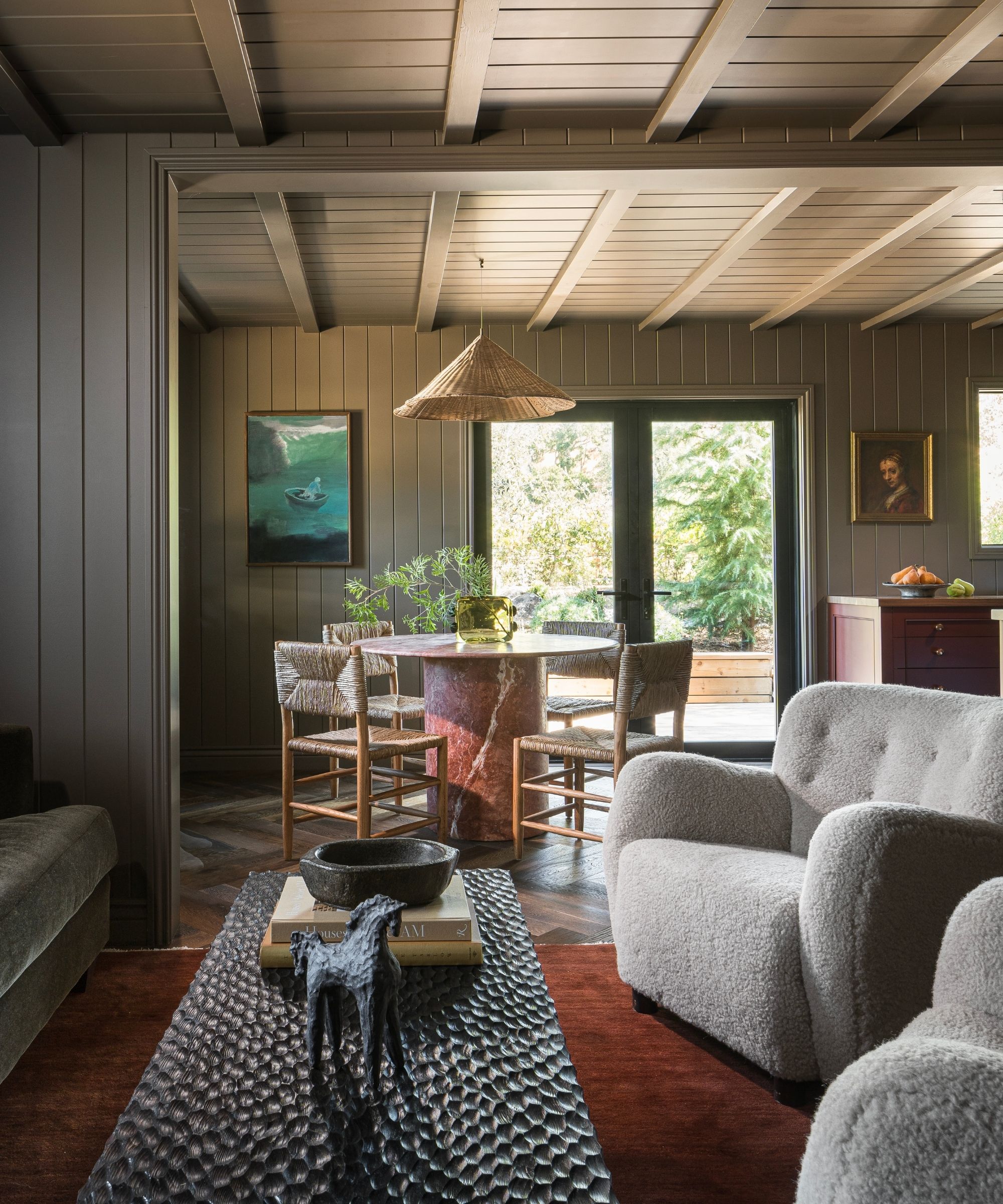 an open concept cottage living area with paneled walls and vintage electic furnishings