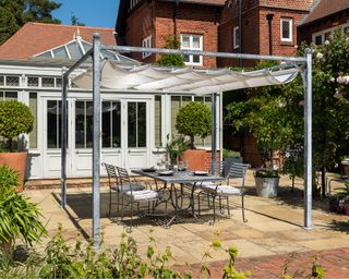 metal pergola over the top of a seating area and flagstone patio