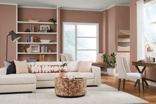 A living room painting in a dusky pink with a cream sofa