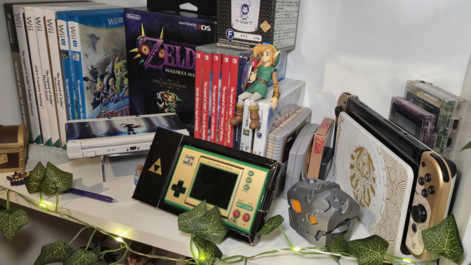 Photo of a shelf of Legend of Zelda collectibles with leaf fairy lights around it.