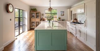 neutral kitchen with sage green kitchen island and wooden parquet flooring