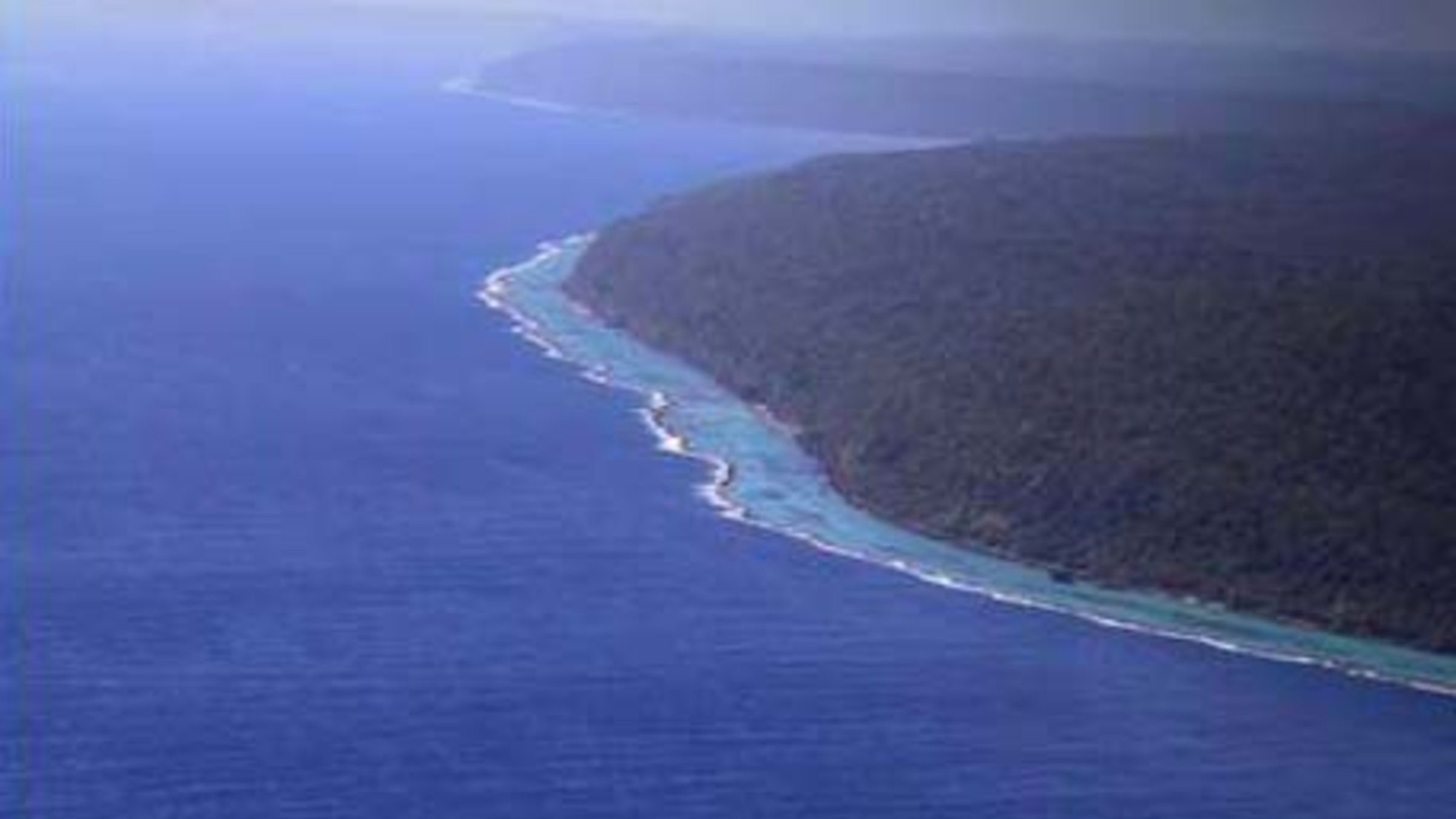 A aerial photo of Rennell Island showing a fringing coral reef skirting its coastline