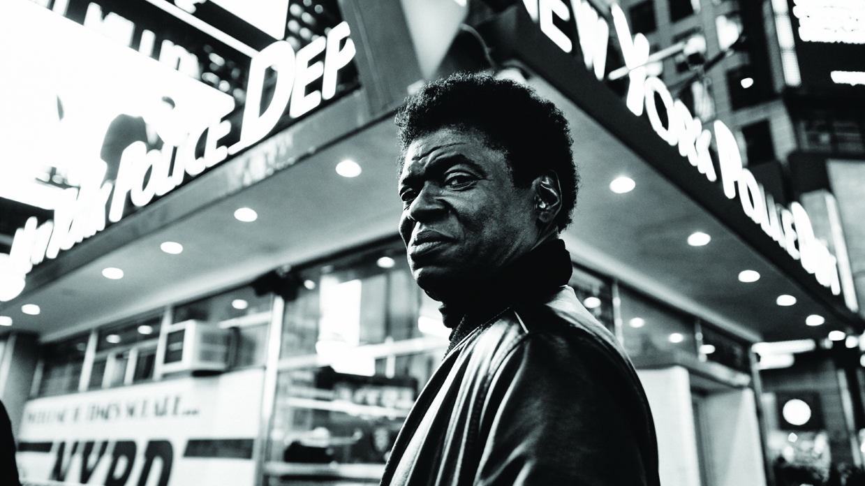 A black and white picture of Charles Bradley standing outside a New York Police Department building.