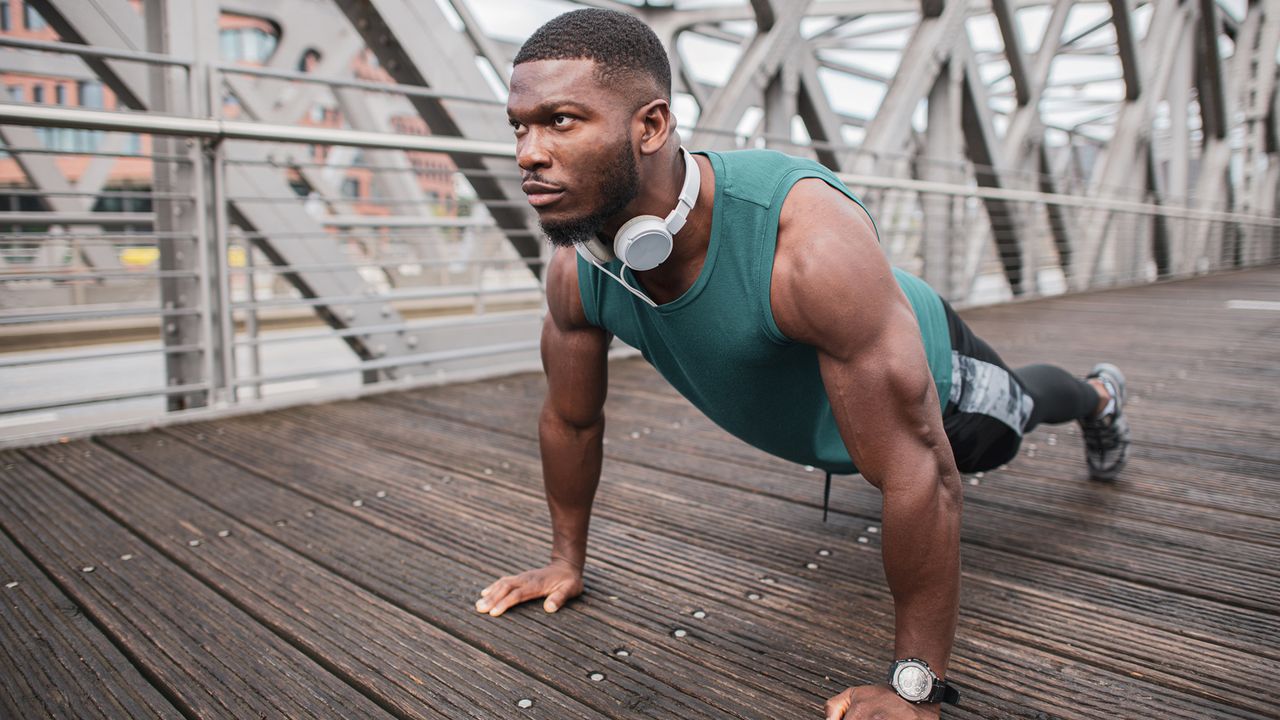 Muscular young man in sportswear, preparing for workout outside