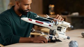 Man admiring Lego Star Wars: X-Wing Starfighter 