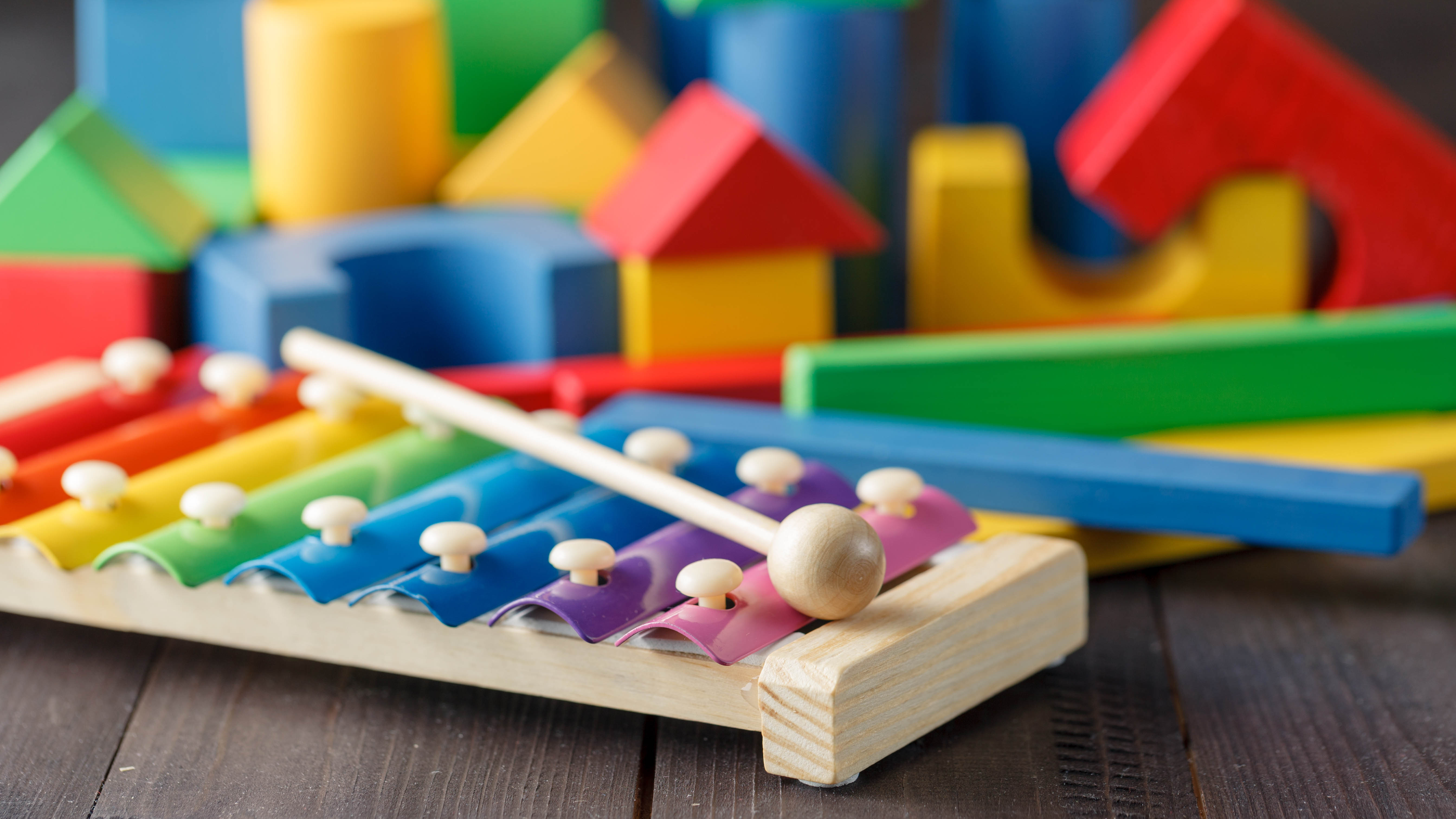Набор детских игрушек, включая ксилофон и строительные кубики.