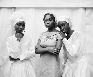 Black and white photo of African women looking at the camera in light clothing