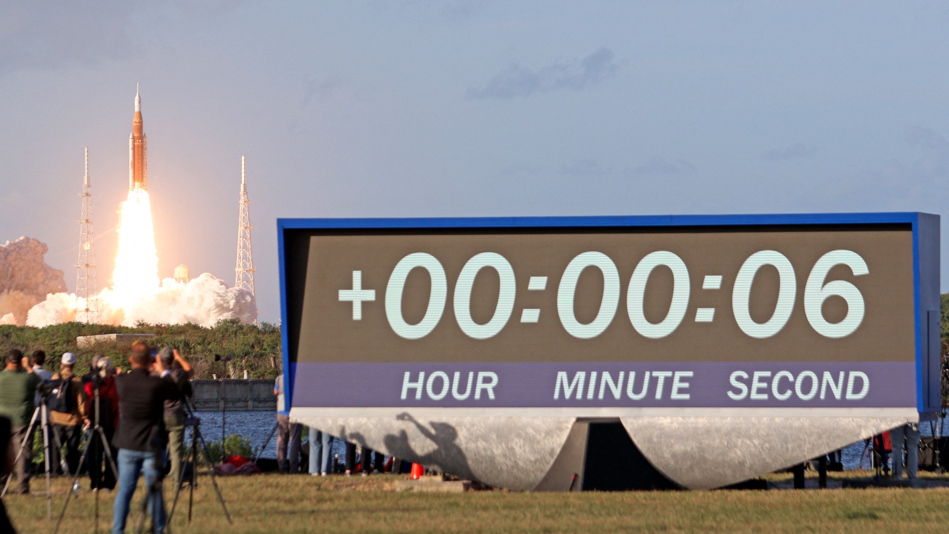 يتم إطلاق صاروخ في الخلفية خلف ساعة العد التنازلي التي تقرأ +06 ثانية