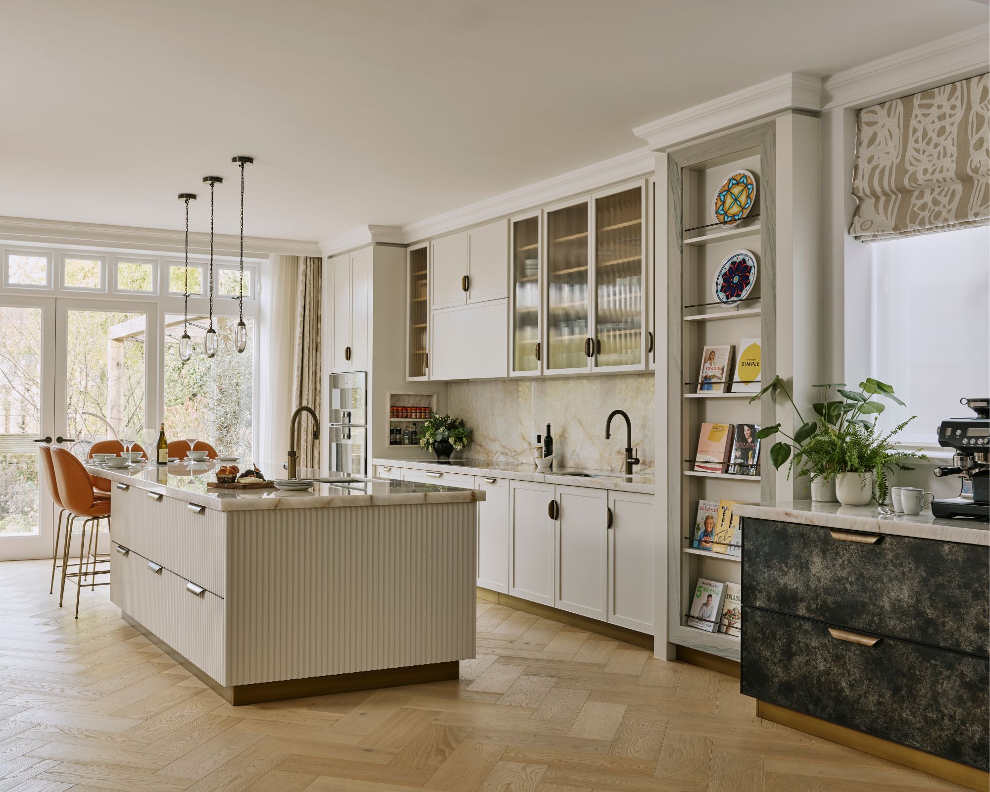 A white kitchen with fluted cabinetry and open shelving for cookbooks