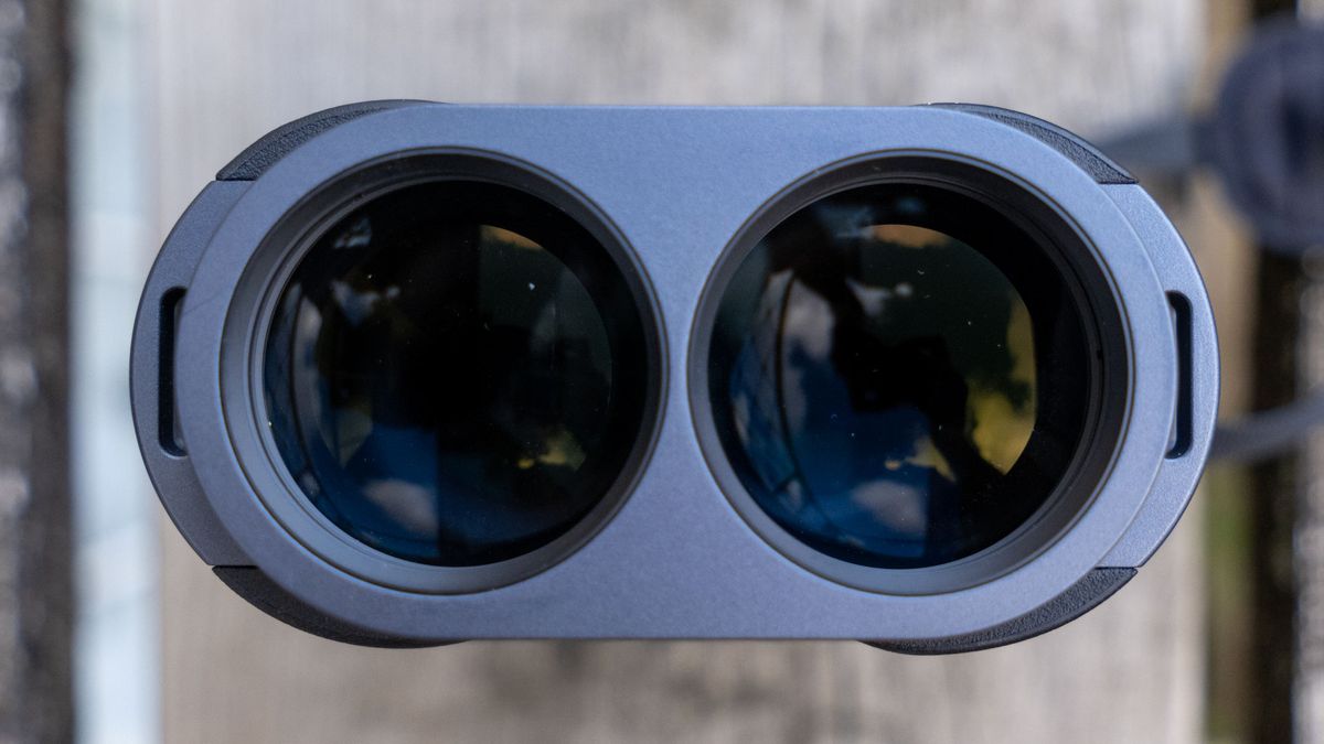 A close-up of the lenses on the Fujifilm Techno-Stabi TS-L 1640 image-stabilized binoculars with wooden planks in the background.