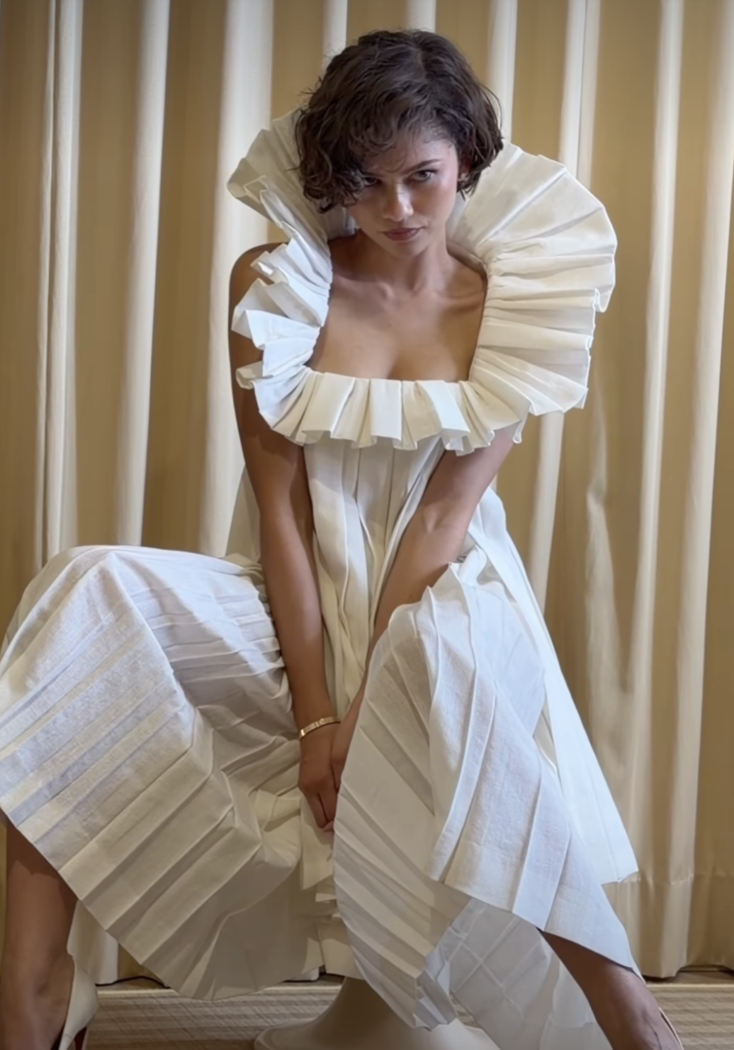 Zendaya wearing two very different Louis Vuitton looks, including a gold matching set and a white structural gown