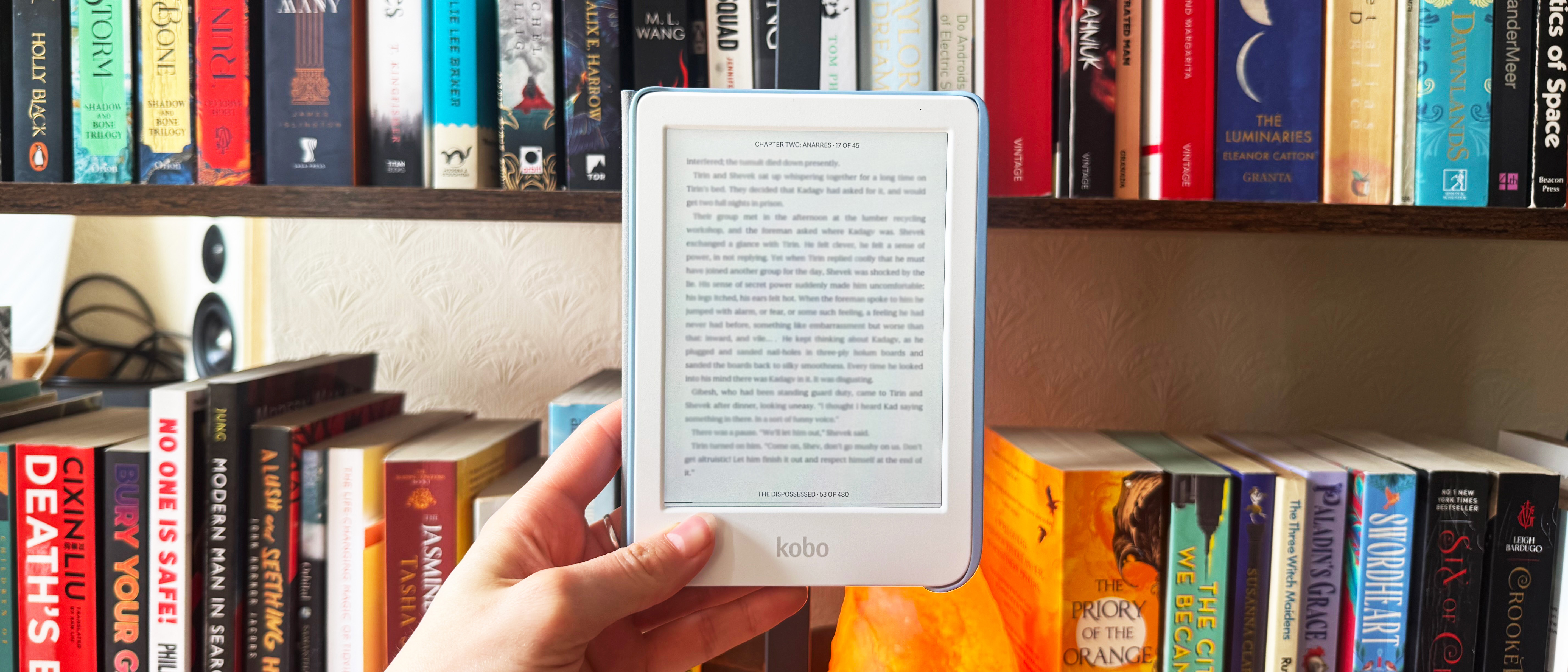 a photo of the kobo clara colour against a bookshelf with a blurred foreground