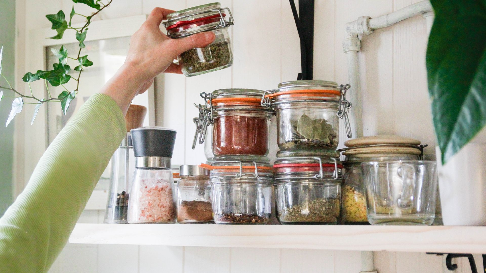 Woman reaching for some herbs in her kitchen