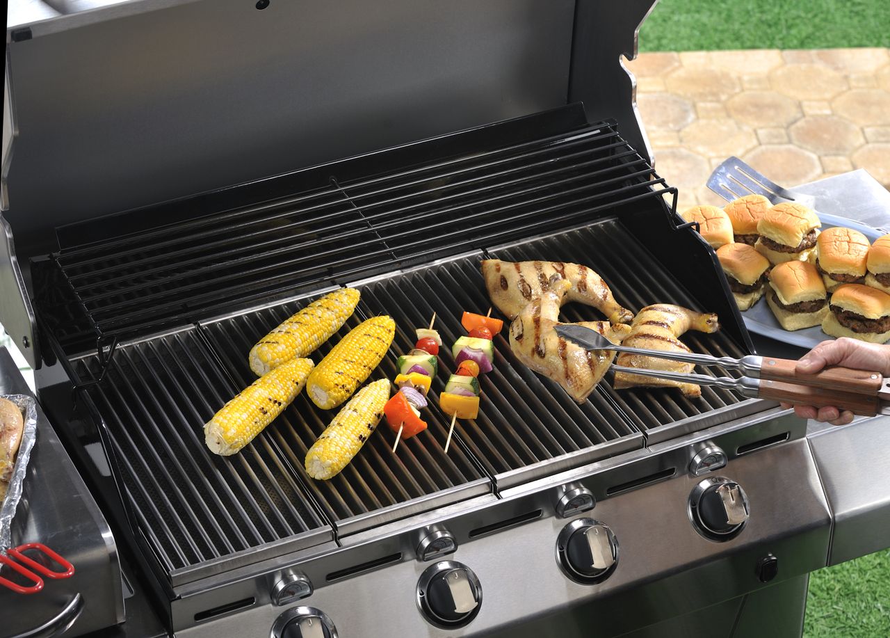 A close up of a gas grill grate cooking food