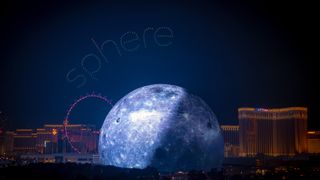 The Vegas Sphere a lit like a moon with drones spelling pout Sphere.