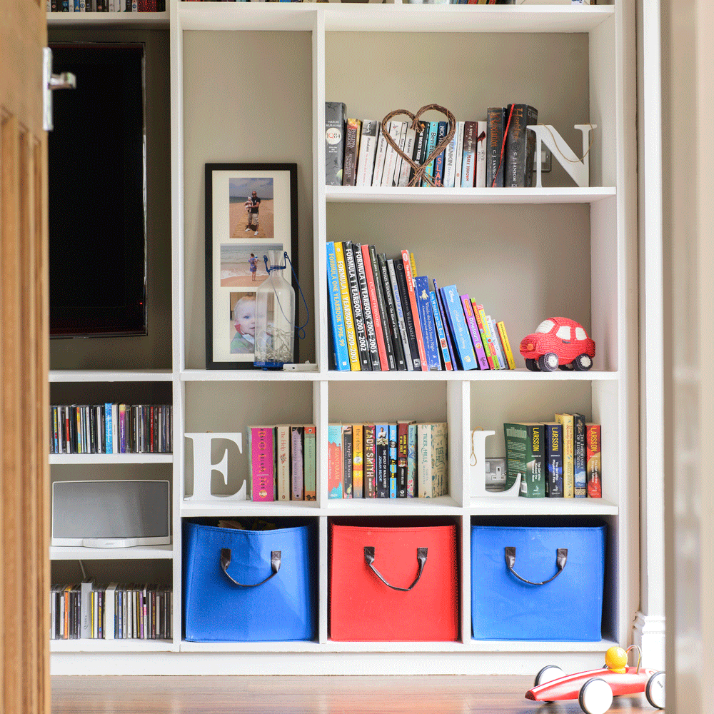 white book shelf with books and toys