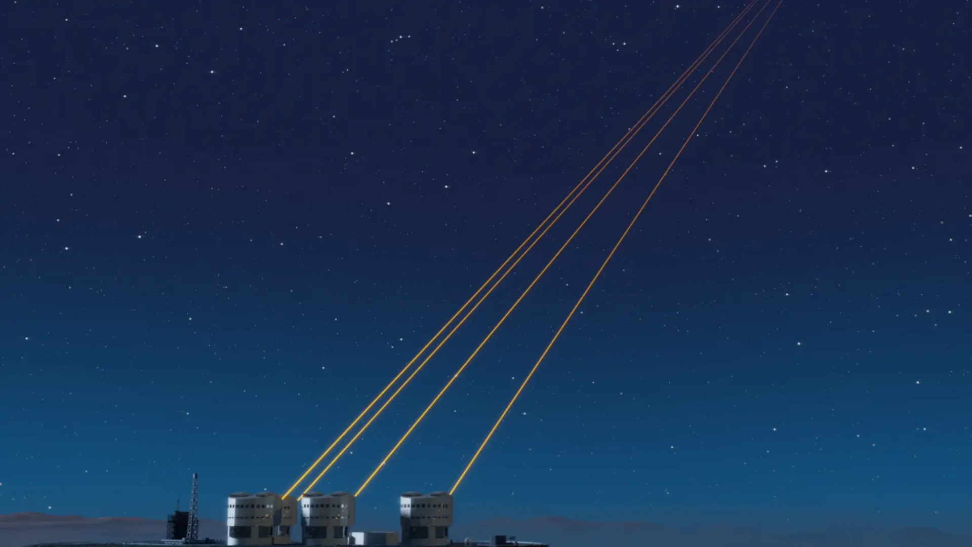 A series of small round buildings at the bottom left of the image with four yellow lasers pointing into the top right of the image over a dark blue night sky.