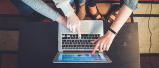 Three people gathered around a laptop