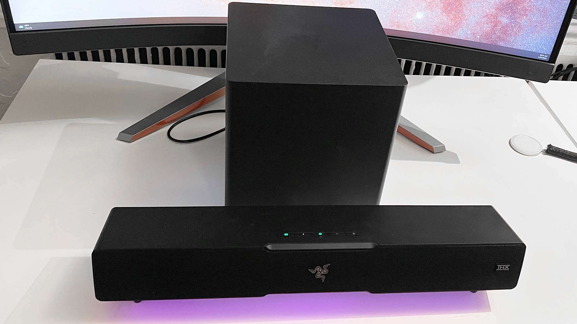 Um Razer Leviathan V2 em uma mesa em frente a um monitor