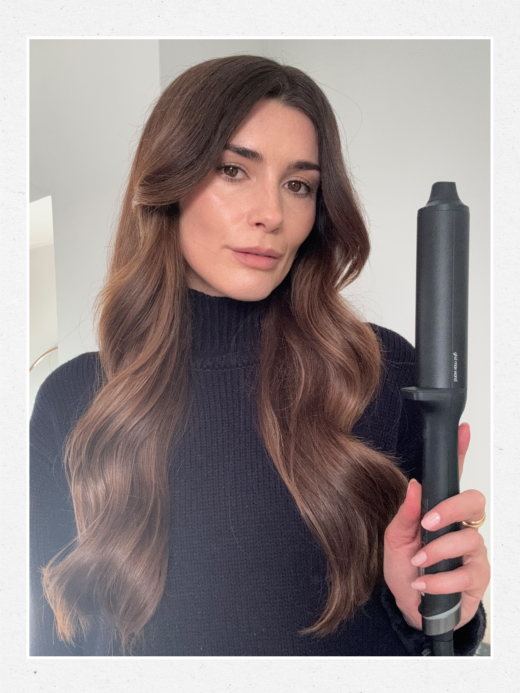 A picture of Eleanor Vousden holding a GHD curling wand with a loose waves hairstyle on her long hair