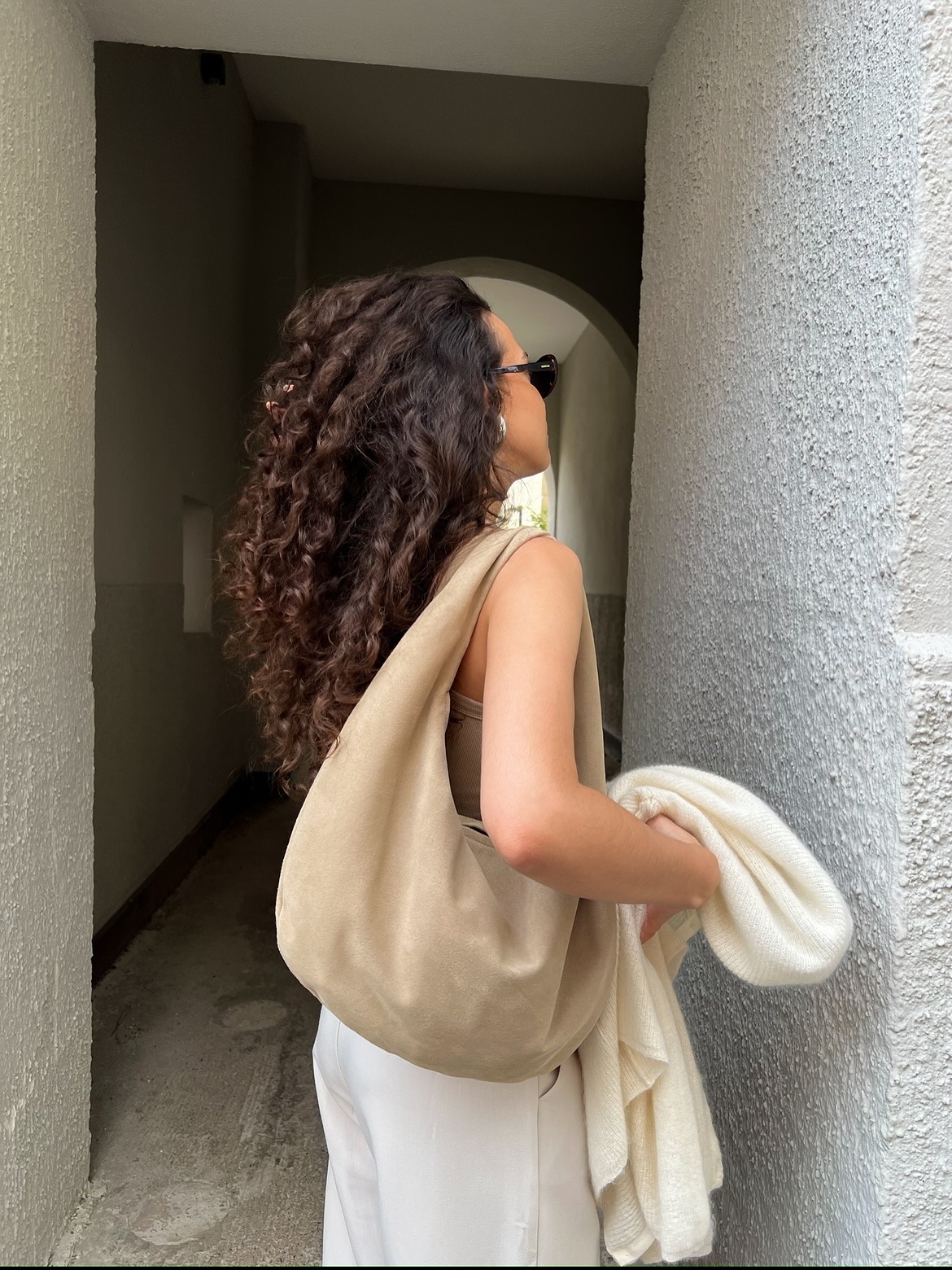 Woman with curly hair facing away from the camera.