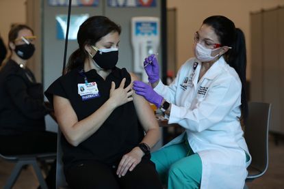A pharmacist in Florida receives her first dose of the coronavirus vaccine.