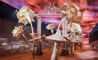 Dior S/S 2022 Texan landscape show set including a red sky and several large flower-like features, designed by ES Devlin