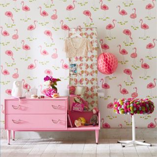 Colorful children's bedroom with pink flamingo wallpaper and pink chest